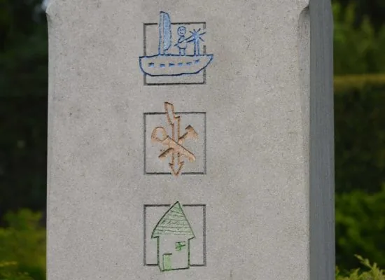Stele mit drei eingehauenen, farbig gefassten Bildzeichen: Segelboot, Anker und Haus
