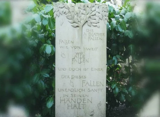 Das ausgeführte Grabmal in hellem Naturstein mit Baumkrone, Blättern, Händen und eingehauenem Gedicht